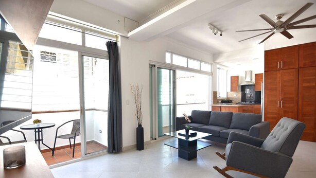 Ein modernes Wohnzimmer mit einer Couch, einem Couchtisch und einem Essbereich mit Tisch und Stühlen.