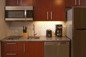 A kitchen with wooden cabinets, a stainless steel microwave, a coffee maker, and a dishwasher. - Orlando | Lakeside Escape | Resort Pool & Theme Parks Nearby (Orlando)