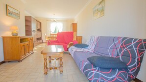 Una sala de estar con un sofá, una mesa de madera y un mueble.