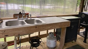 Una cocina con encimera de madera, un lavamanos y una estufa a gas.