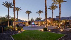 A residential property with a central fountain, surrounded by palm trees and a well-maintained lawn. - 7BR Luxury Oasis w/ Relaxing Lazy River, Basketball, Full Gym & Private Theater (Paradise Valley)