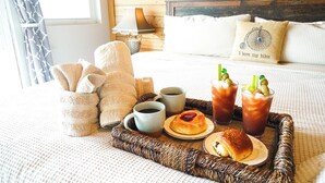 A neatly made bed with a pillow that says "I love my bike," a tray with drinks, and a basket of towels. - Waterfront 5-bed 4 bath with heated pool BTR 2030 (Indian Rocks Beach)
