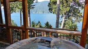 A hot tub with a view of a lake and forest.