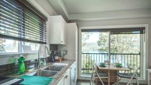 A kitchen with a granite countertop, a sink, and a dining area with a table and chairs.