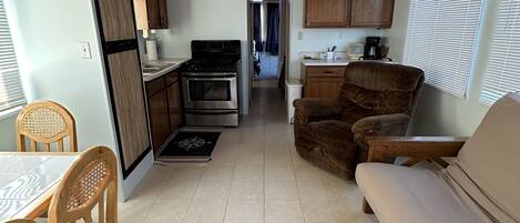 Interior compacto de autocaravana con kitchenette, comedor y zona de estar.