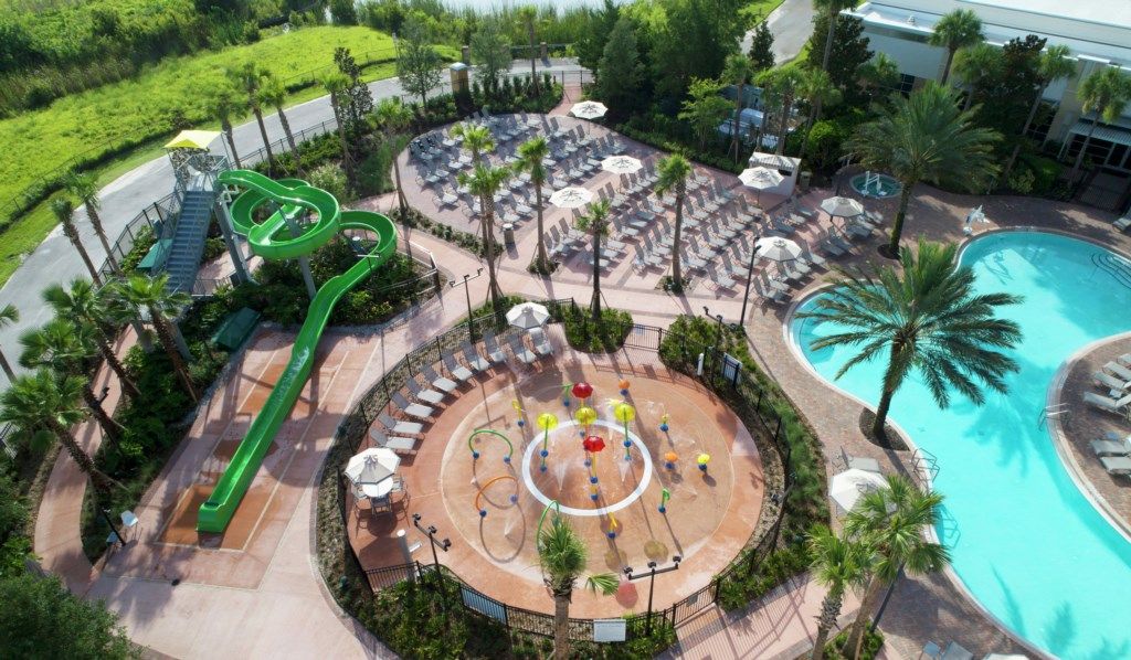 A resort with a pool, lounge area, and a water slide.