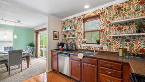 A kitchen with wooden cabinets, a dishwasher, and a window with a view. - Skyline Views, Park For Free and Walk To Downtown, PPG, Convention Center (Pittsburgh)