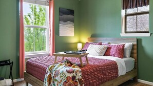 A bedroom with a bed, a bedside table with a lamp, a window with curtains, and a painting on the wall. - Skyline Views, Park For Free and Walk To Downtown, PPG, Convention Center (Pittsburgh)