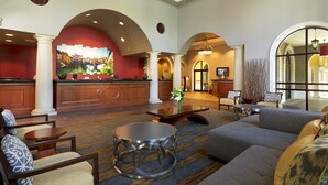 A spacious lobby with a reception desk, seating area, and a large window. - Orlando | Couples Resort Pad | Pool + Hot Tub (Orlando)