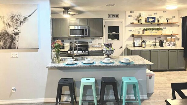 A modern kitchen with a central island, bar stools, and a sign reading "EL PASO". - Modern Open House w POOL, close to Fort Bliss (El Paso)