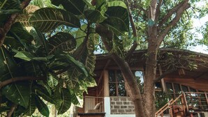 Una casa en un árbol con una escalera de madera y fachada de ladrillo.