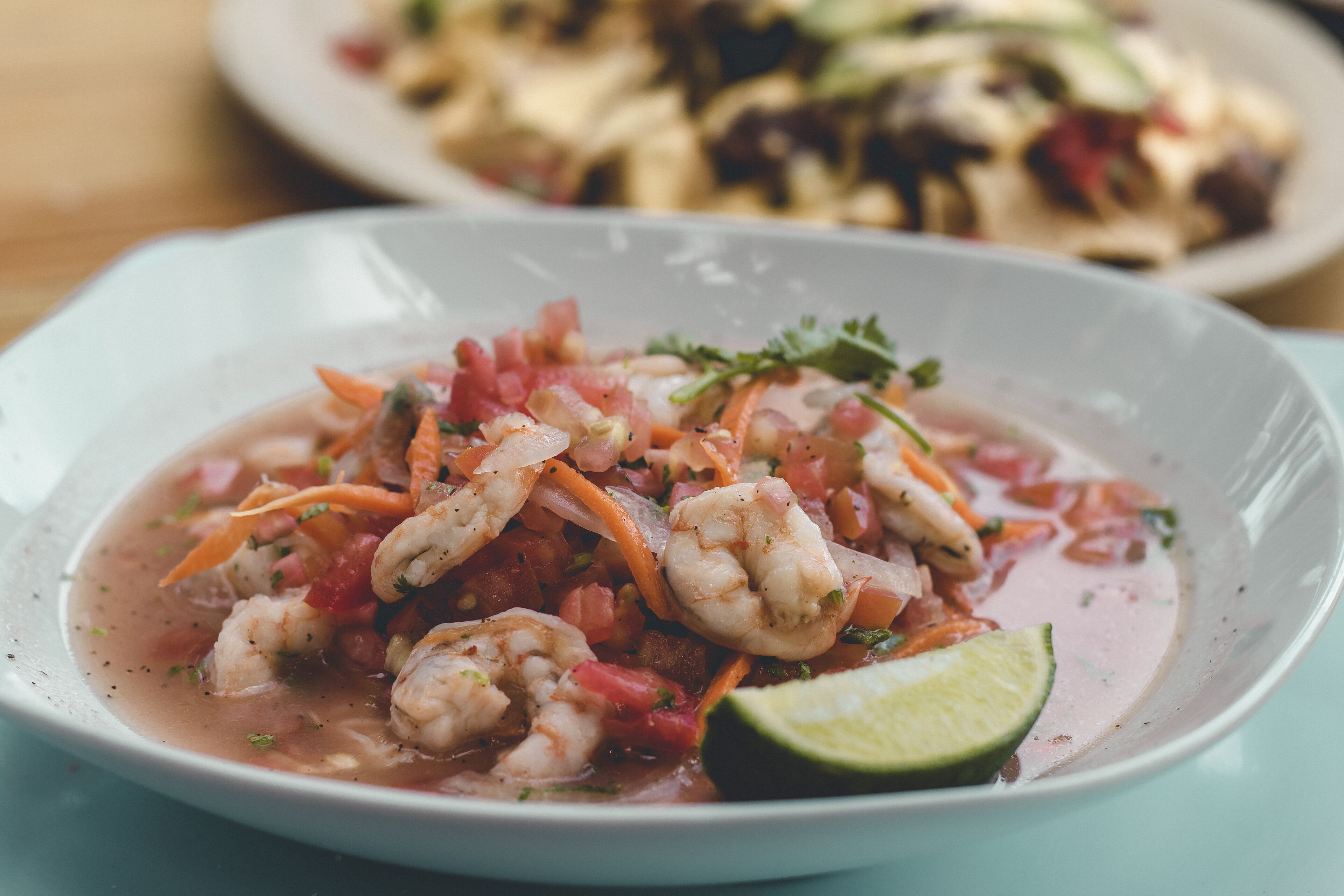 Un plato de ceviche de camarones con limón y hierbas.
