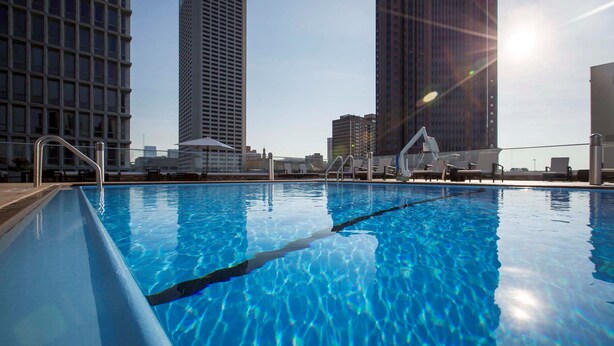A swimming pool with clear blue water, surrounded by tall buildings, and a sunny sky. - 1 Bedroom | Free Daily Breakfast, Gym (Atlanta)
