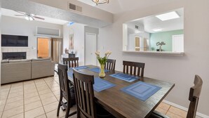 A dining area with a wooden table, blue placemats, and six chairs.