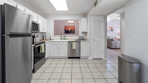 A modern kitchen with stainless steel appliances, white cabinets, and a central island.