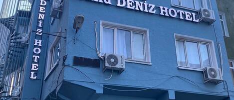 A blue building with the sign "Grand Deniz Hotel" on the facade.