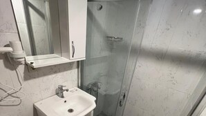 A modern bathroom with a glass shower enclosure, a white sink, and a mirror above the sink. - GRAND Deniz Hotel (Istanbul)