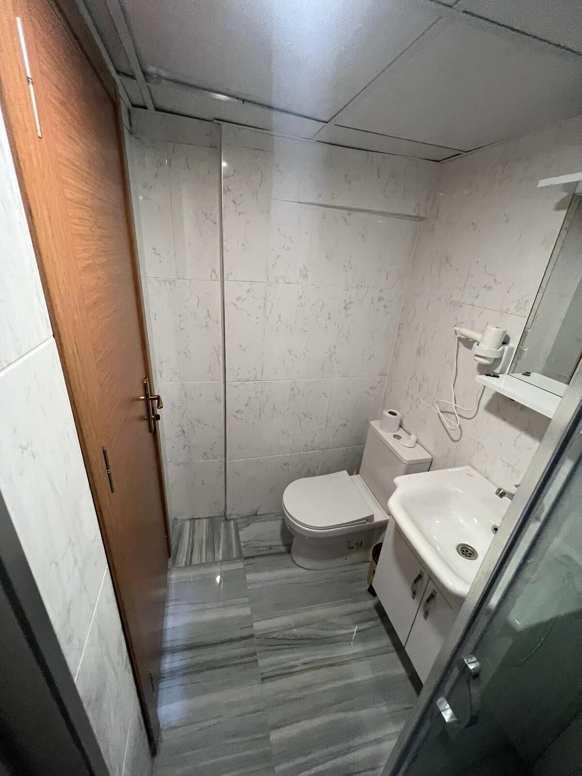 A compact bathroom with a toilet, bidet, and sink.