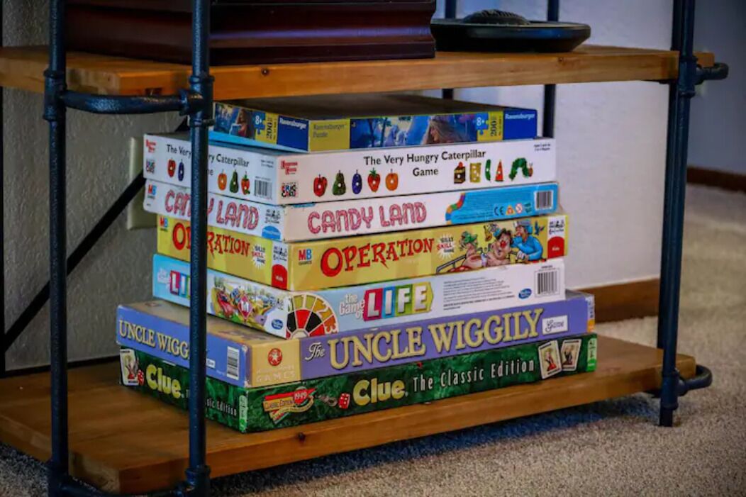 A shelf with various board games, including Candy Land, Operation, and Uncle Wiggly.