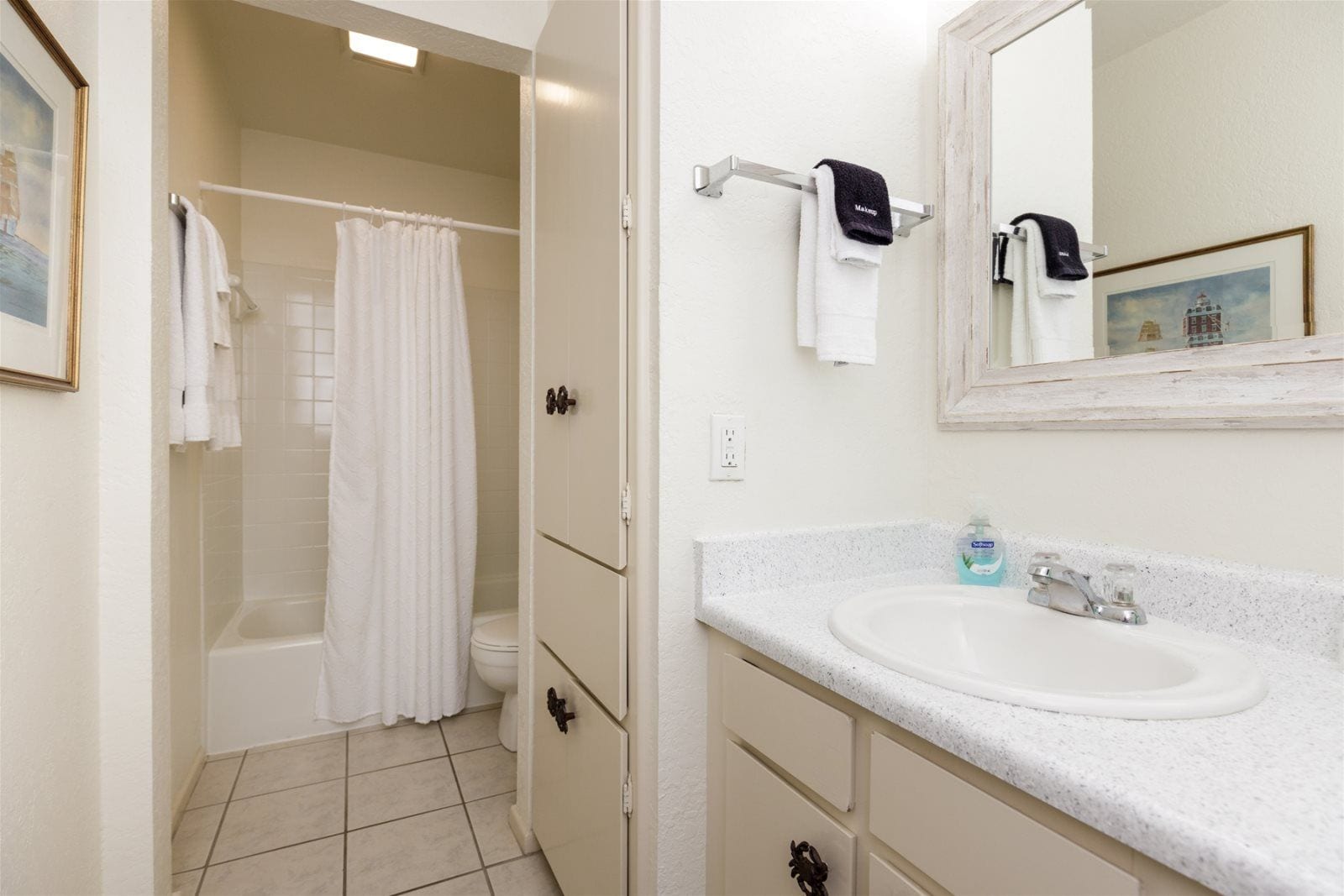 A bathroom with a bathtub, a shower, a sink, and a mirror.