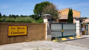 Ein begrenzter Eingang mit einem Schild, auf dem 'Les Mazets de Camargue' steht.