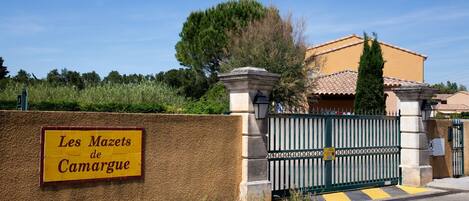 A gated entrance with a sign reading "Les Mazets de Camargue".