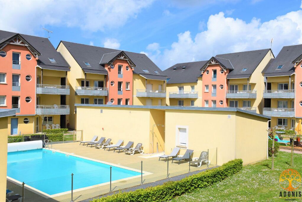 A hotel with a swimming pool, multiple balconies, and a garden area.