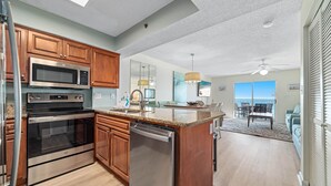 Eine moderne Küche mit Edelstahlgeräten, Holzschränken und einer großen Kochinsel.
