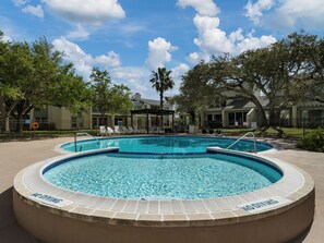 A swimming pool with a 'No Diving' sign, surrounded by lounge chairs and trees. - Golden Gull by Miss Kitty’s (Rockport)