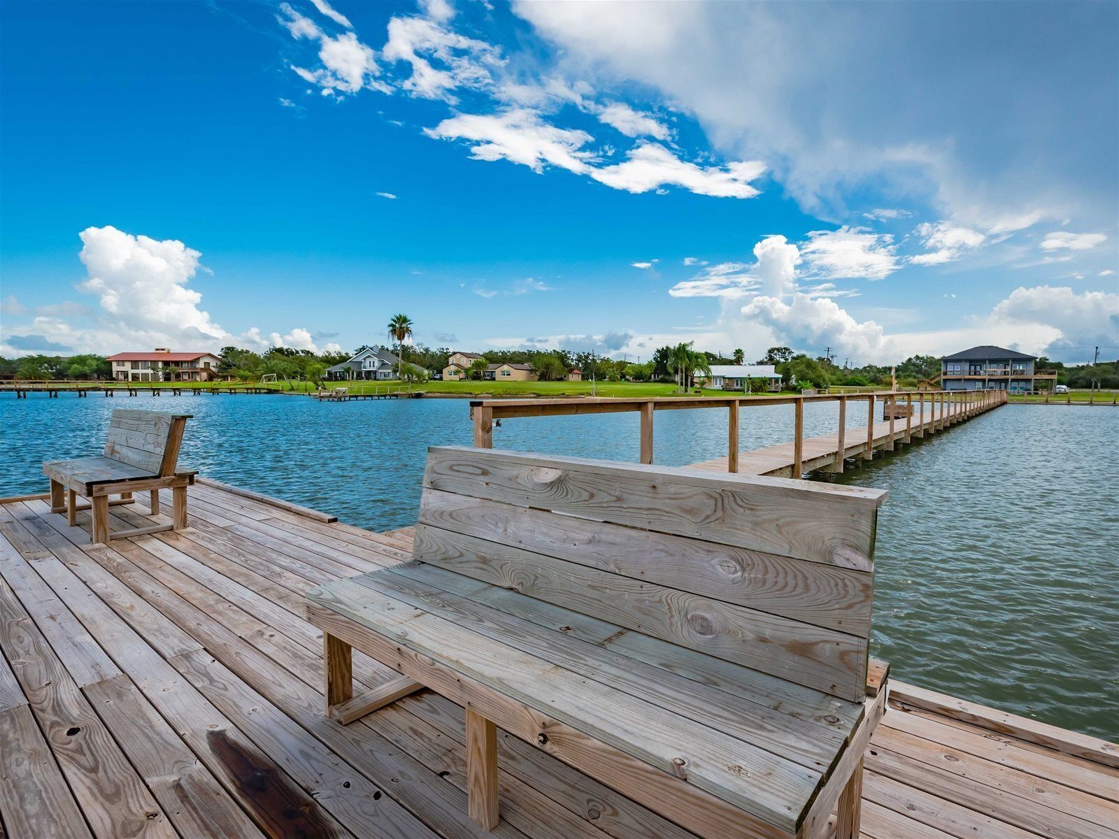 A wooden pier extending into a body of water with a clear sky above.