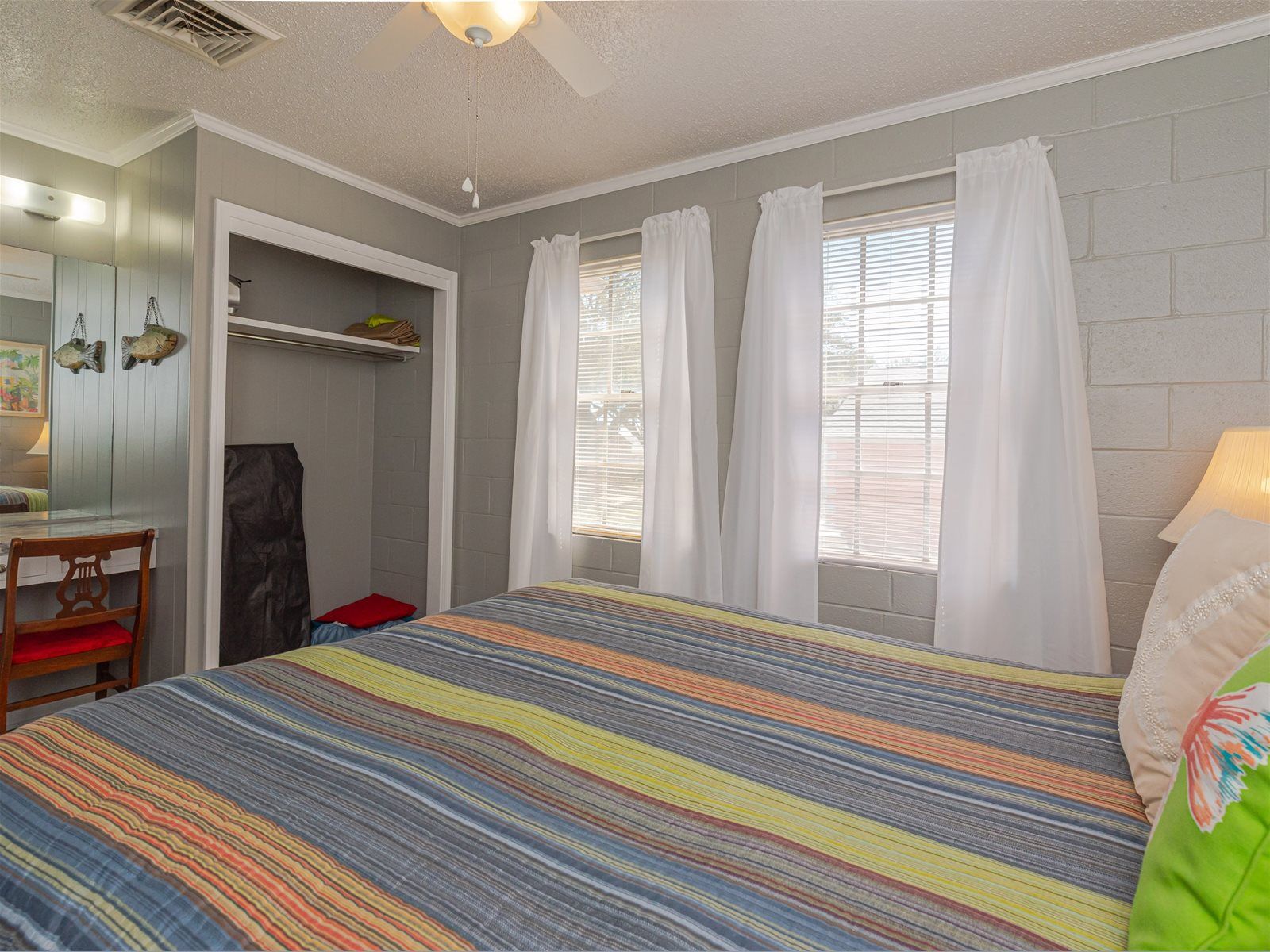 A bedroom with a bed, a desk, and a closet.