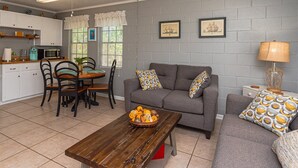 Un espacio habitable pequeño con kitchenette, comedor y zona de estar.