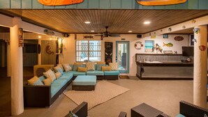 A cozy lobby with a large seating area, a reception desk, and decorative fish wall art. - Texas Tiki by Miss Kitty’s (Rockport)