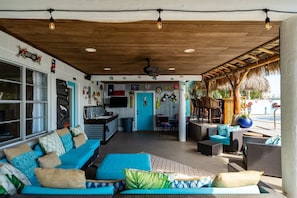 Un espacio al aire libre techado con una barra, una cocina y un comedor.