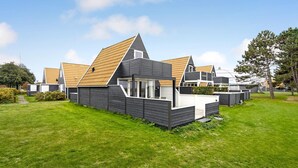 A modern vacation home with a large deck, a covered outdoor area, and a well-maintained lawn. - Beautiful home in Gedser with kitchen (Gedser)