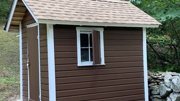 A small wooden shed with a pitched roof and a single window.