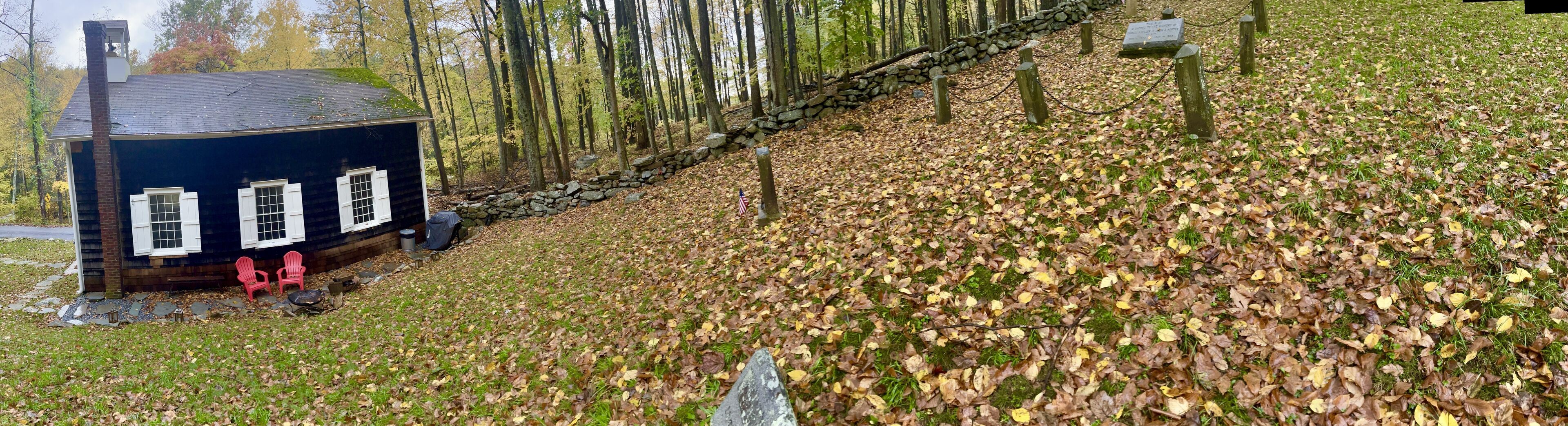 A rustic cabin with a stone wall and a stone staircase leading up to it.