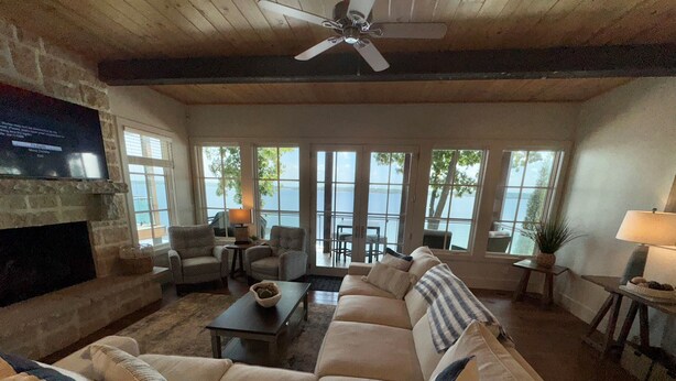 A spacious living room with a large sofa, a fireplace, and a view of the outdoors.