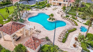 A resort with a large swimming pool, lounge areas, and palm trees. - Luxury Minorca ~ Corner Unit ~ Ocean & River Views! 2 Balconies! Paros 606 (New Smyrna Beach)