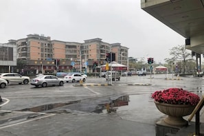 A multi-story building with a wet street in front.