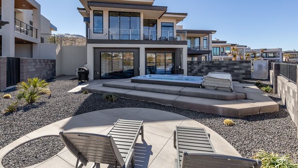 Une maison moderne à deux étages, dotée d’une piscine, d’un espace salon extérieur et d’un jardin aménagé.