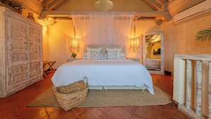 A bedroom with a large bed, wooden ceiling beams, a white canopy, and a rustic cabinet. - Moet Cartagena Hotel Boutique  - Adults Only (Cartagena)