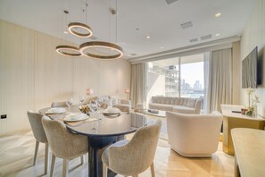 Une chambre d’hôtel moderne dotée d’un coin repas, d’un canapé et d’une télévision.