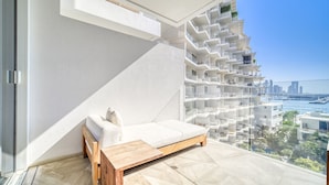 Un apartament modern amb un sofà blanc, una panxa de fusta i vista a la ciutat.