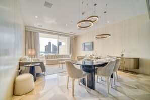 Un espace repas moderne avec une table ronde, des chaises et des luminaires suspendus.