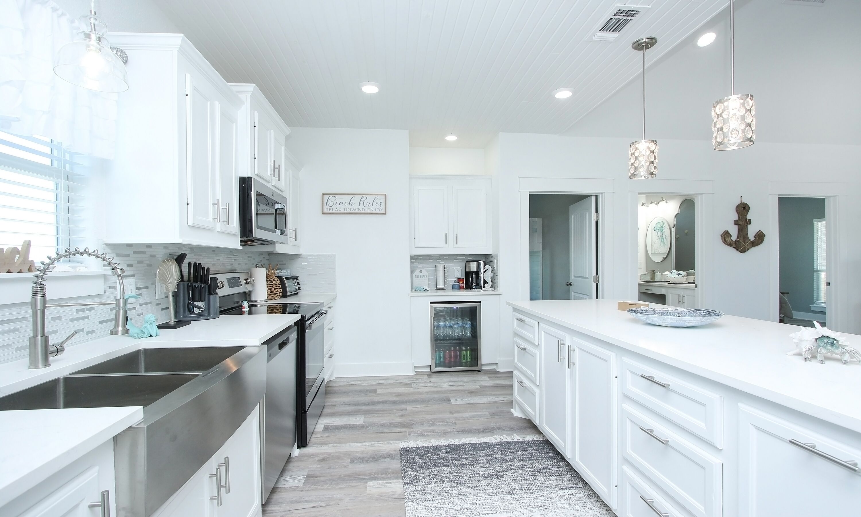 A modern kitchen with white cabinetry, stainless steel appliances, and a central island.