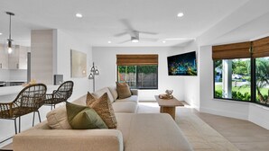 A modern living room with a sofa, chairs, a coffee table, and a cityscape painting. - 501 Managed By Brampton Park (Delray Beach)