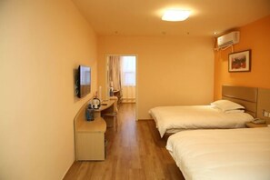 A hotel room with two beds, a desk with a chair, a television, and an air conditioning unit. - Grace Inn (Yutai Bus Station) (Yutai)