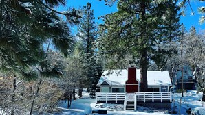 A cabin with a red chimney, surrounded by snow-covered trees and a clear sky. - Romantic Winter Escape with Mountain Views (Running Spring (Arrowbear lake area))