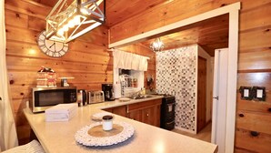 A kitchen with wooden walls, a microwave, a coffee maker, and a sink. - Romantic Winter Escape with Mountain Views (Running Spring (Arrowbear lake area))